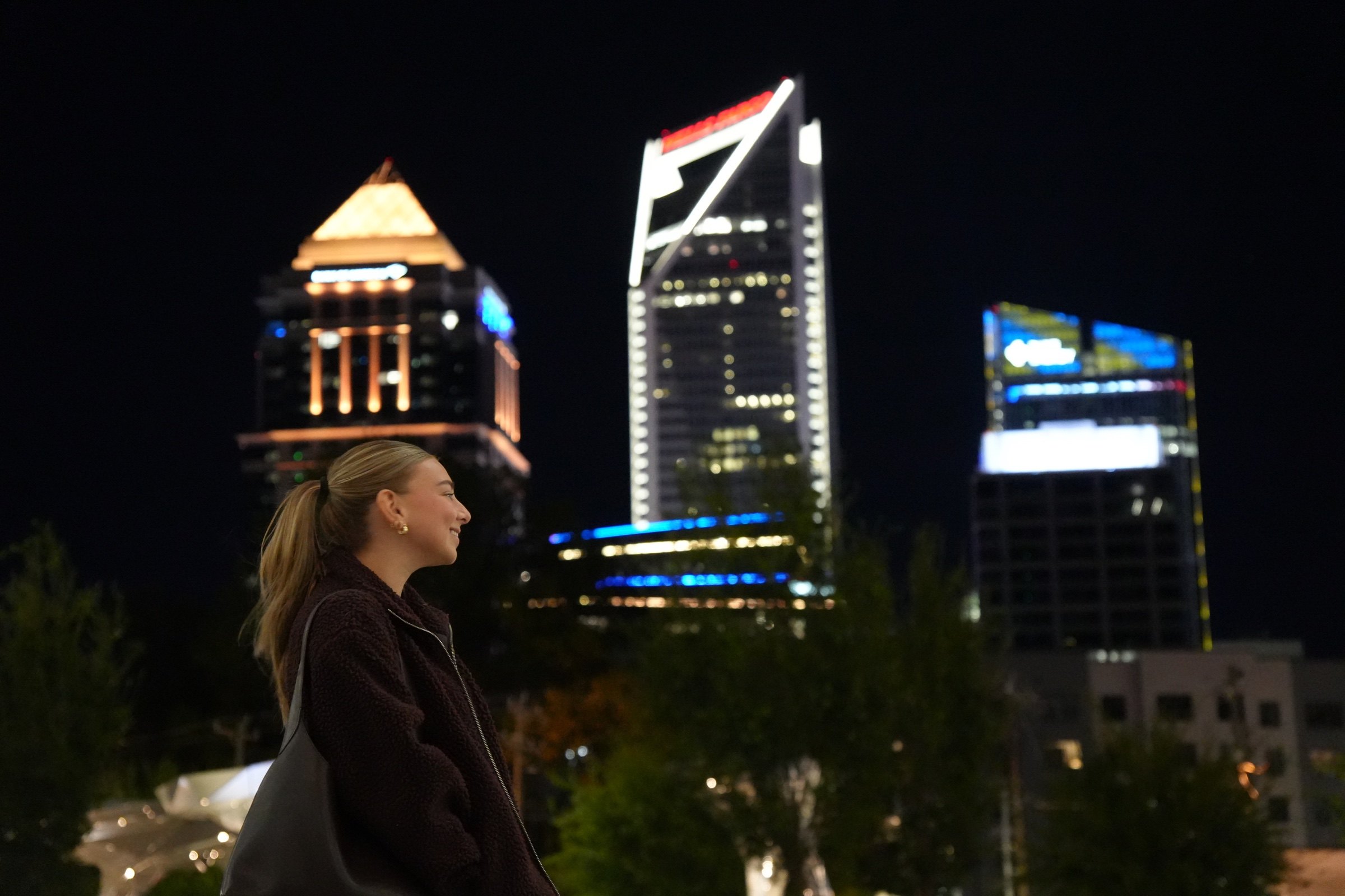 Portrait beneath illuminated city buildings