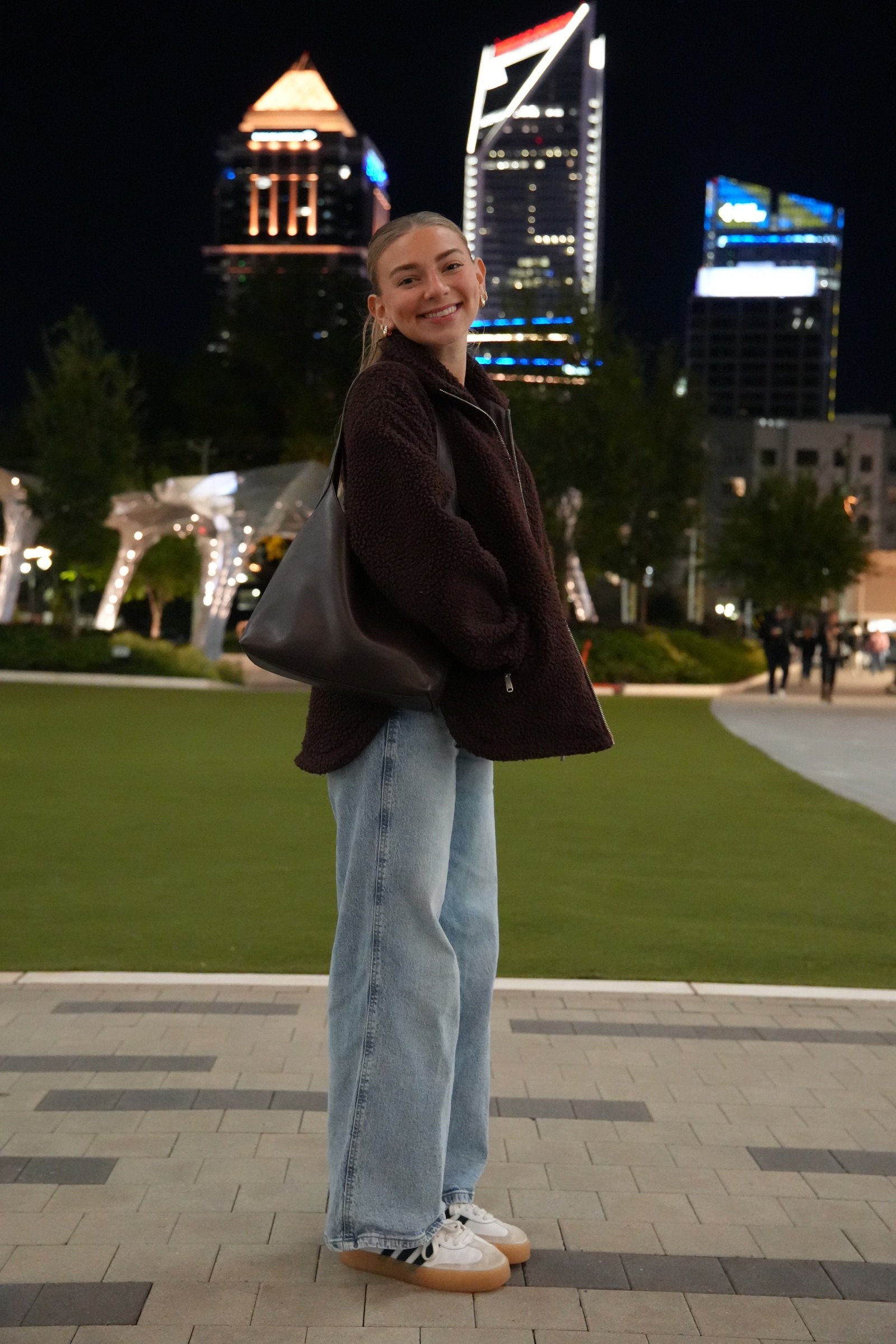 Full-length portrait beneath illuminated city buildings